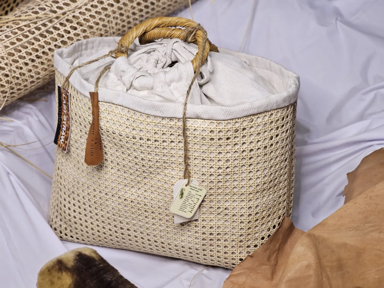 Close-up of a woven cane fashion bag with a wooden handle