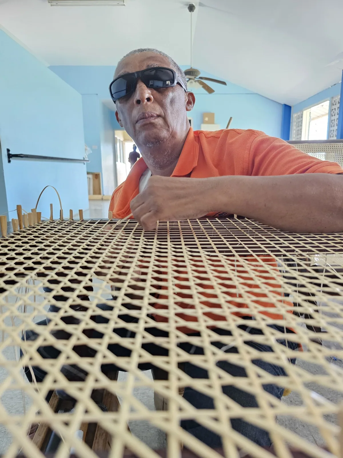 Artisan carefully weaving a cane chair by hand